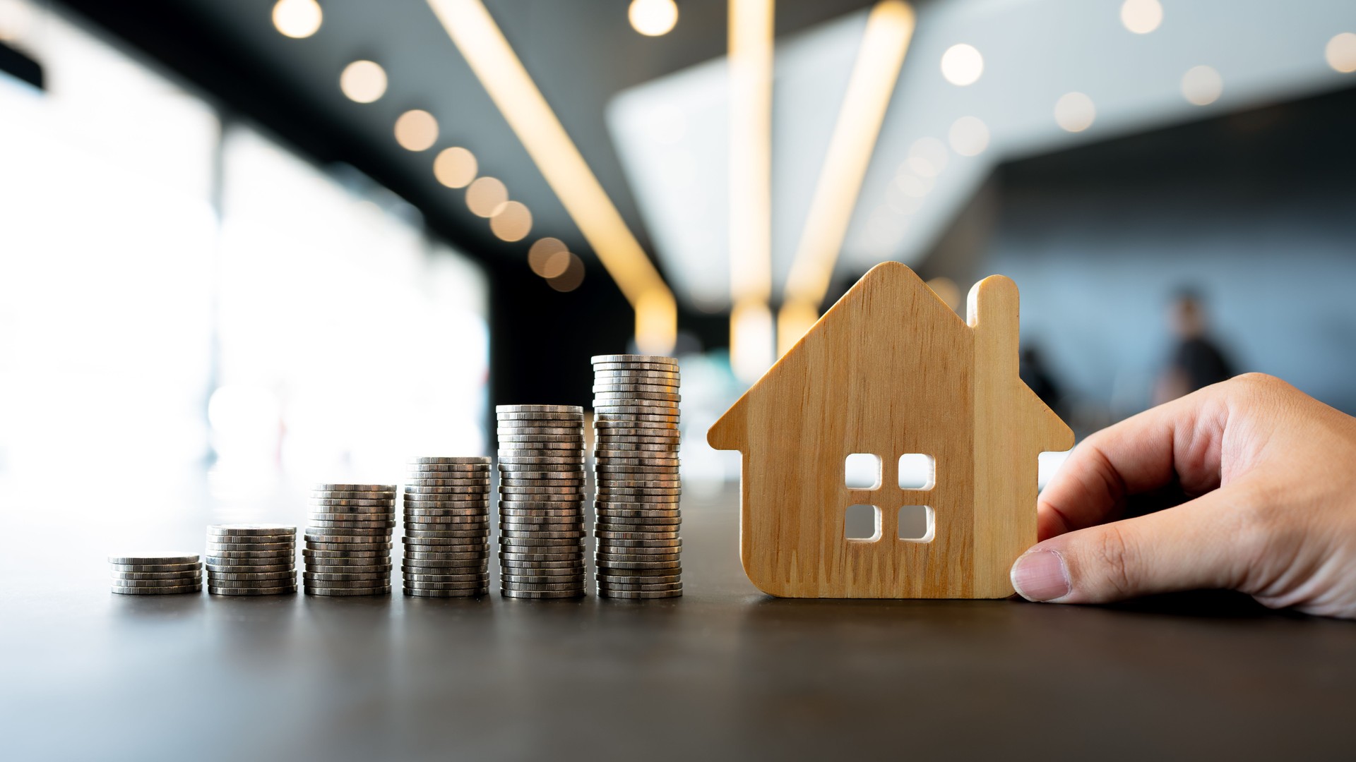 Wood house and row of coin money on wood table and , selective focus, Planning to buy property. Choose what's the best. A symbol for construction ,ecology, loan concepts.